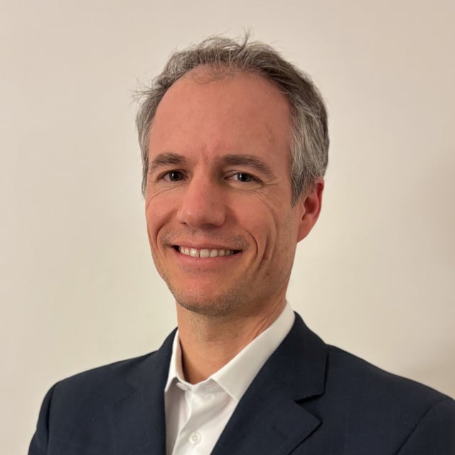 Portrait d'agent immobilier professionnel en place parisienne élégante, incarnant l'expertise en biens haut de gamme et un service immobilier de confiance.