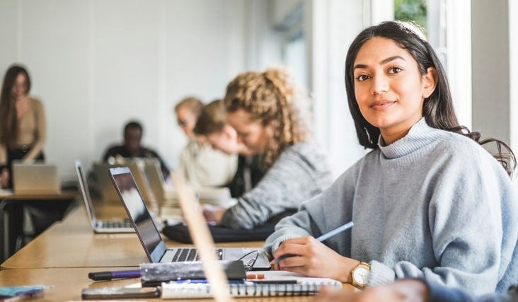 Jeune professionnelle de l'immobilier à son bureau dans un espace de travail contemporain et lumineux, prête à accompagner ses clients dans leurs projets immobiliers