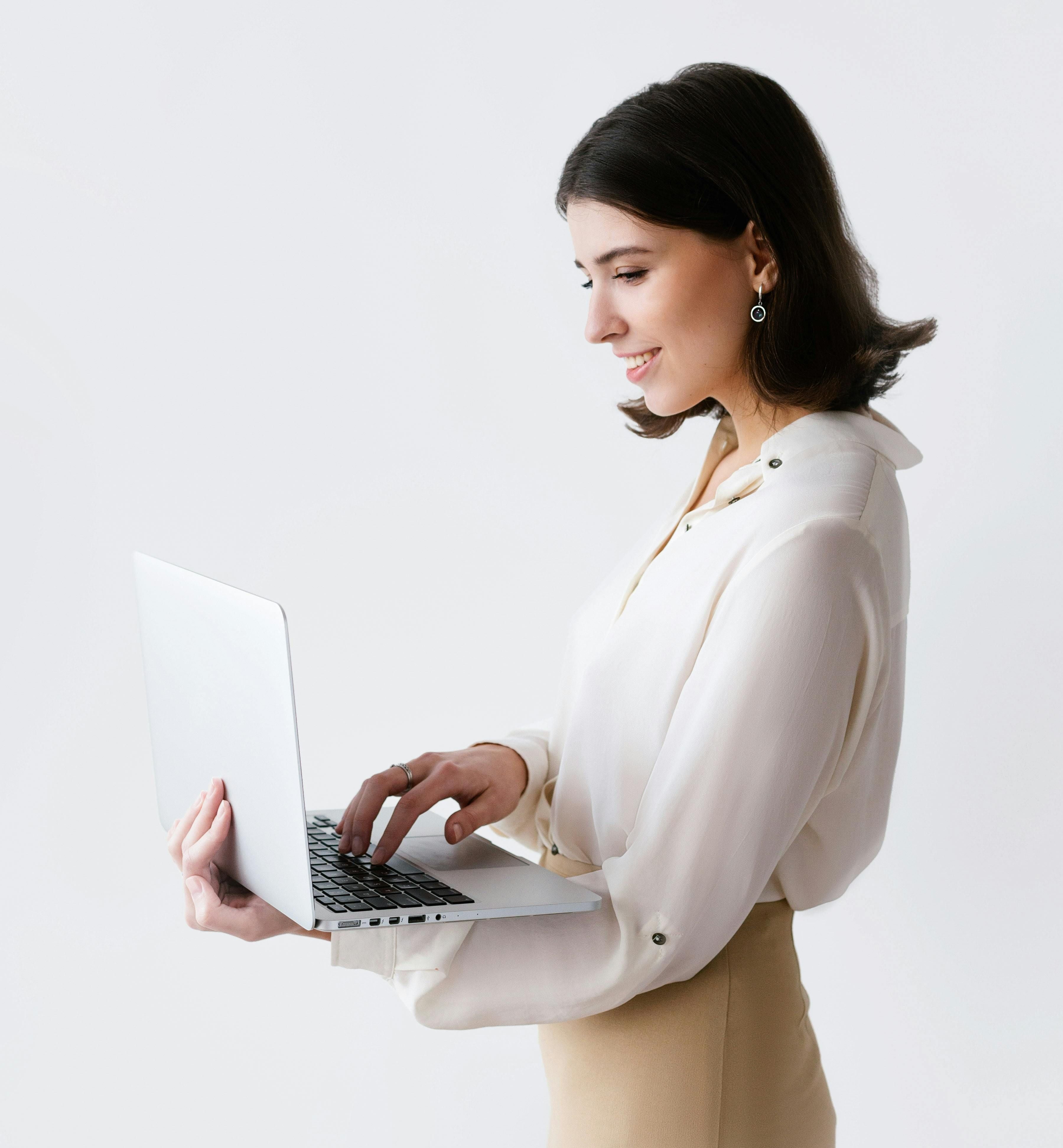 Professional woman using laptop in bright, minimalist space. Modern workspace featuring clean lines, natural lighting, and contemporary design—ideal for luxury rental properties.