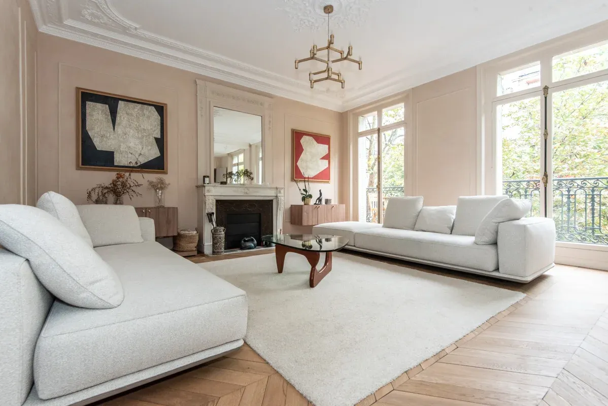 Luxurious bright living room with soaring ceilings, fireplace, and floor-to-ceiling windows overlooking private balcony. Contemporary design with premium furnishings.